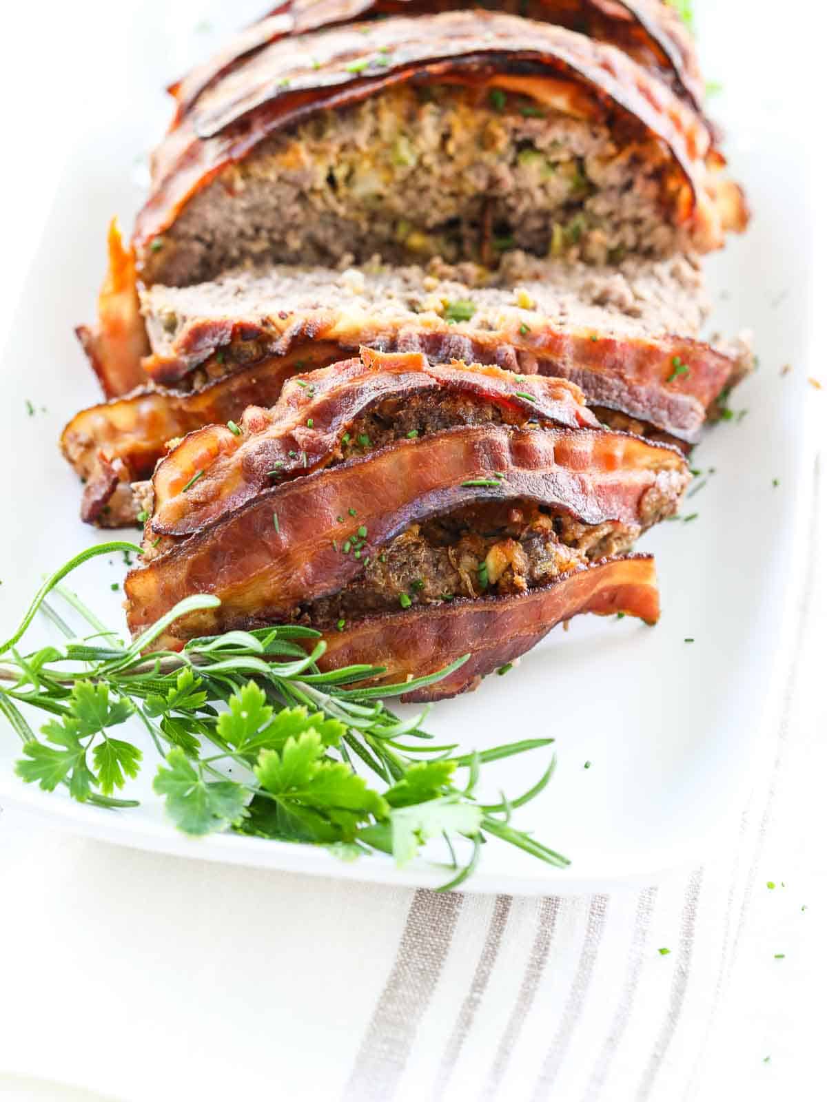 https://www.delicioustable.com/wp-content/uploads/2022/01/Close-up-of-Meatloaf-stuffed-and-bacon-wrapped.jpg